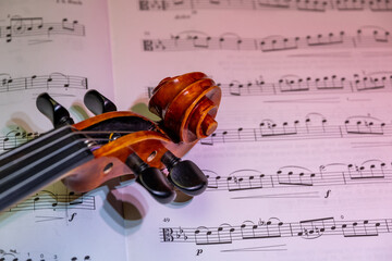 Detailansicht einer Geige mit Schnecke und Wirbelkasten vor Noten, Studioaufnahme, Deutschland
