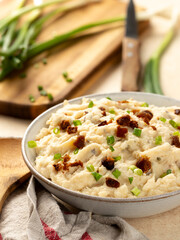 Bowl of mashed potatoes with bacon and green onion