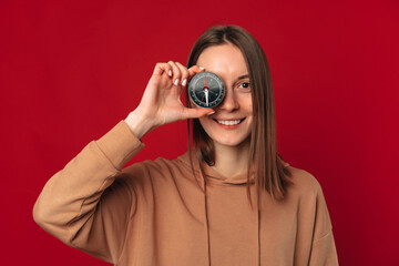 Ecstatic young woman covers one eye with a compass for life decisions and guidance.