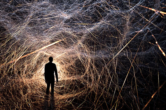 Surreal image of a man's silhouette with a cobweb around, concept of confusion, addiction and mental problems