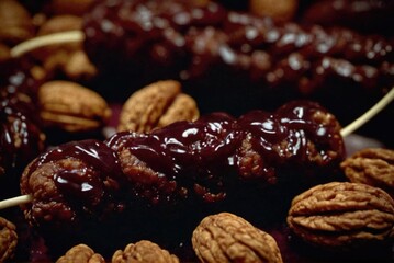 Obraz premium A traditional candy made from walnuts or hazelnuts threaded onto a string, dipped in thickened grape juice by ai generated