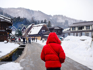 Tourists admire the snow-covered village scenery.