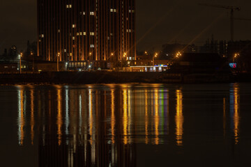 KYIV, UKRAINE - JANUARY 28, 2024: Kyiv in the evening and Dnipro river. the light from the windows reflects well on the water. walk from the embankment to the right bank of Kyiv and the bridge.