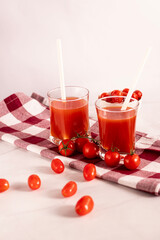 Tomato juice in a glass and fresh tomatoes. on a white background. food