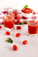 Tomato juice in a glass and fresh tomatoes. on a white background. food