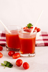 Tomato juice in a glass and fresh tomatoes. on a white background. food