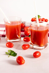 Tomato juice in a glass and fresh tomatoes. on a white background. food