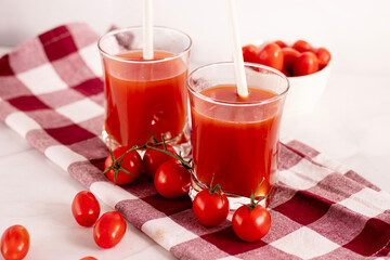 Tomato juice in a glass and fresh tomatoes. on a white background. food