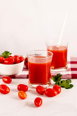 Tomato juice in a glass and fresh tomatoes. on a white background. food