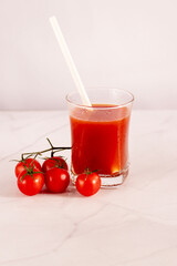 Tomato juice in a glass and fresh tomatoes. on a white background. food