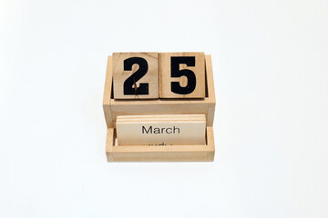 Close up of a wooden perpetual calendar showing the 25th of March. Shot close up isolated on a white background