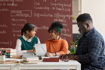 Group of young African American people discussing school project in classroom setting