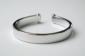 Minimalist style silver bracelet, semi-open, with a reflective surface on a light background