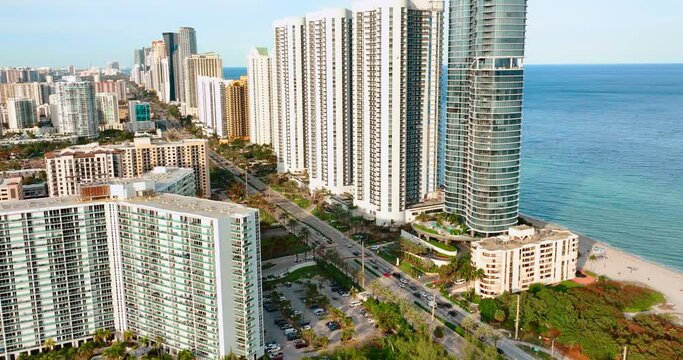 Tops of high-rise buildings on beach Sunny Isles Beach Florida. Collins Ave with cars. Oceanfront with apartments.