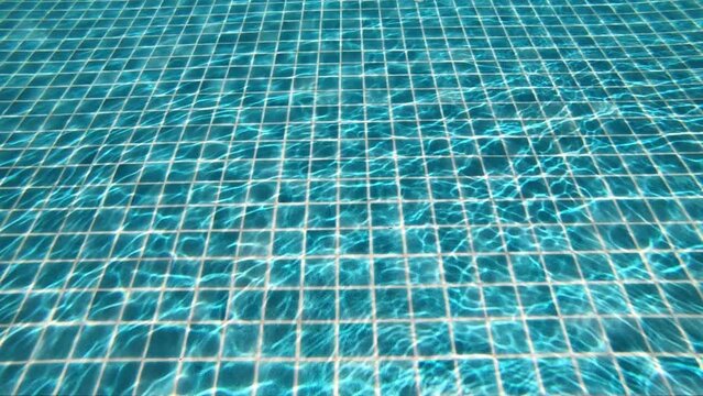 underwater view of outdoor swimming pool, the sun's ray pass through the water slow motion scene