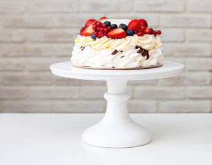 Pavlova cake with whipped cream cheese, chocolate sauce and fresh berries on grey background. Beautiful cake for the Birthday party