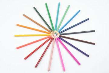 A group of seamless coloured wooden pencils arranged in circle photographed on white background