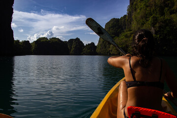 Athletic woman paddling a canoe.