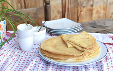 traditional french homemade pancakes  in a plate served on a table with red and white tablecloth