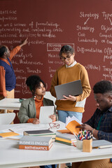 Vertical portrait of African American college students doing group study in college classroom with...
