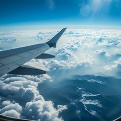 Fototapeta premium aerial view from an airplane, capturing the landscape below with patches of clouds and distant mountains. The clarity of the sky and the sense of altitude evoke a feeling of freedom and adventure