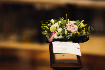 Bridal bouquet resting on kneeler during a wedding. - 723945070