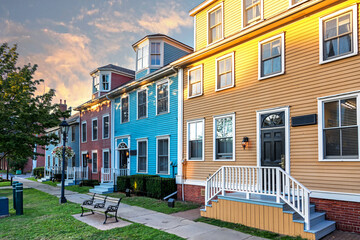 The sun sets on a row of the colorful Victorian clapboard houses in Charlottetown, capital of Prince Edward Island, Canada - obrazy, fototapety, plakaty