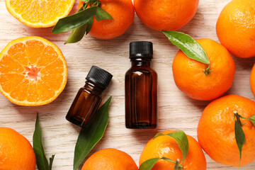 Flat lay composition with tangerine essential oil on wooden table