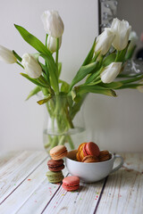 Romantic still life with a cup of cocoa, macarons and tulips