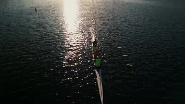 Drone shot of a rowing team rowing in an ocean bay at a beautiful sunrise, Halifax, Canada. Aerial view of kayaking and canoeing synchronized team of athletes training in the Atlantic ocean 