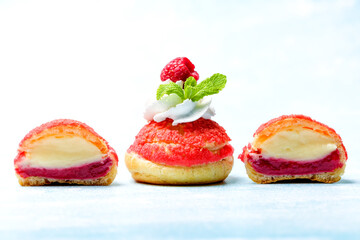 Shu cake. Custard dessert with creamy white cream, decorated with raspberries. Copy space