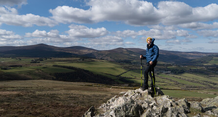 Man climber on top of Sugarloaf Mountain in Wicklow Ireland