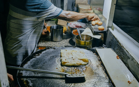 Making process of Martabak Telor. Savoury pan-fried pastry stuffed with egg, meat and spices.