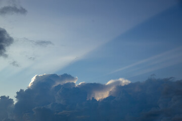 Clouds in the blue sky at sunset. Natural background and texture. Clouds over the village in the evening.  Ornamental clouds. Dramatic sky. Epic storm cloudscape. Soft sunlight. Panoramic image,