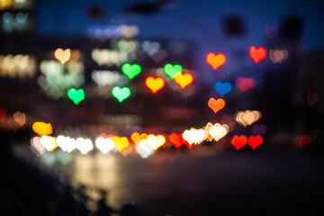 Cityscape with blurred traffic lights and heart-shaped cars on the eve of Valentine's Day
