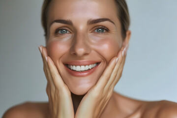 Closeup Beautiful smiling mature woman touch face with smooth healthy skin
