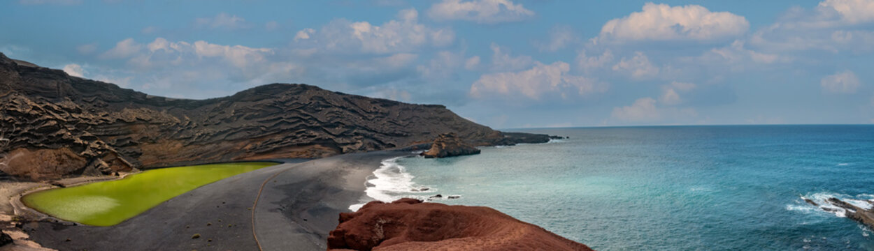 Stunning view of the imploded volcano caldera on the shores of the island of Lanzarote, Canary Islands. On the left the green lagoon at the center of the volcano