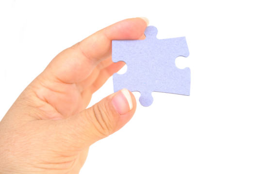 female hand holds cardboard puzzle piece, logical skills, puzzle solving and memory improvement, business concept for completing