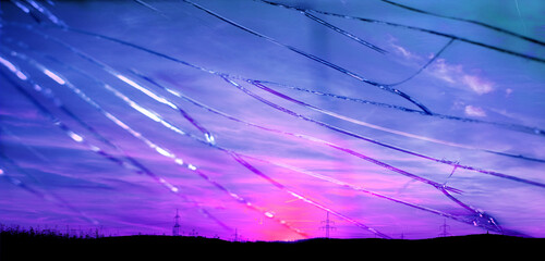 beautiful dramatic landscape, sky with airplane trail lines, power towers, field in evening in rays...