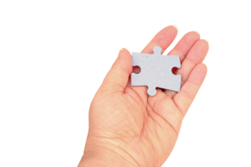 female hand holds cardboard puzzle piece, logical skills, puzzle solving and memory improvement, business concept for completing