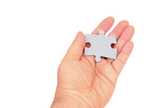 female hand holds cardboard puzzle piece, logical skills, puzzle solving and memory improvement, business concept for completing