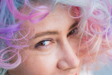 Cropped portrait of curly Caucasian woman with multi-colored hair. Model for hairstyles