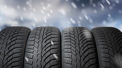 View on snow tires for car during winter. Snowing in background.
