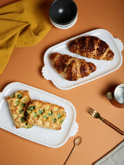 Fresh baked pastries sweet and savory on warm toned table