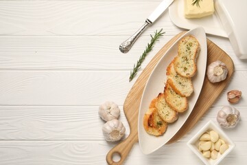 Tasty baguette with garlic and dill served on white wooden table, flat lay. Space for text