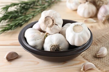 Bulbs and cloves of fresh garlic on wooden table, closeup