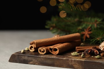 Board with different aromatic spices on light table, closeup. Space for text