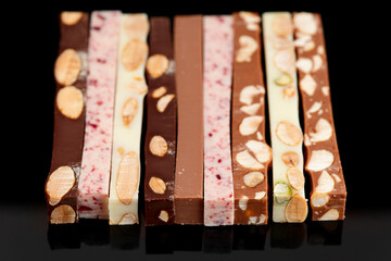 Set of different chocolate bars on black background