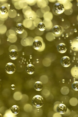 Golden bubbles against a gold bokeh background.