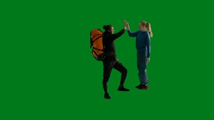 Fototapeta na wymiar A couple rejoicing in shared success, high fiving each other. Tourists, man and woman in studio on green screen. Teamwork concept. Family hiking.